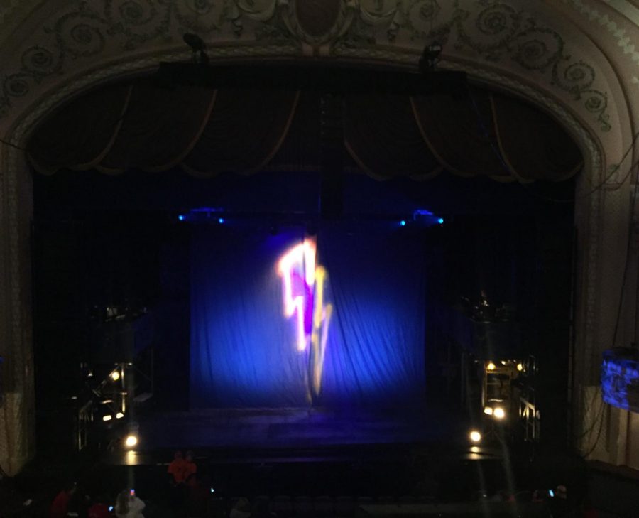A lighting bolt is projected on the curtains before the show starts.