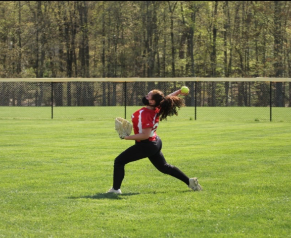 Senior Rachel Bliss throws the softball to the infield during warmups.