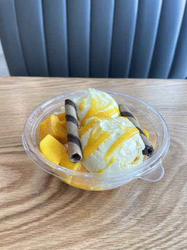 Mango Mangos mango sundae is mango ice cream topped with chunks of mango, sweet sauces and two chocolate cookie rods.