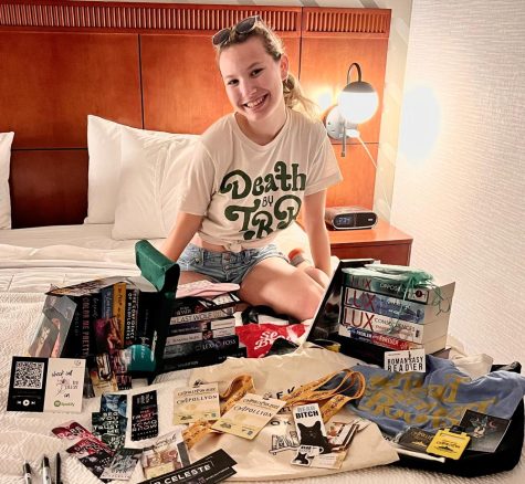 Lampf displays the many book souvenirs that she came home with from the convention. 