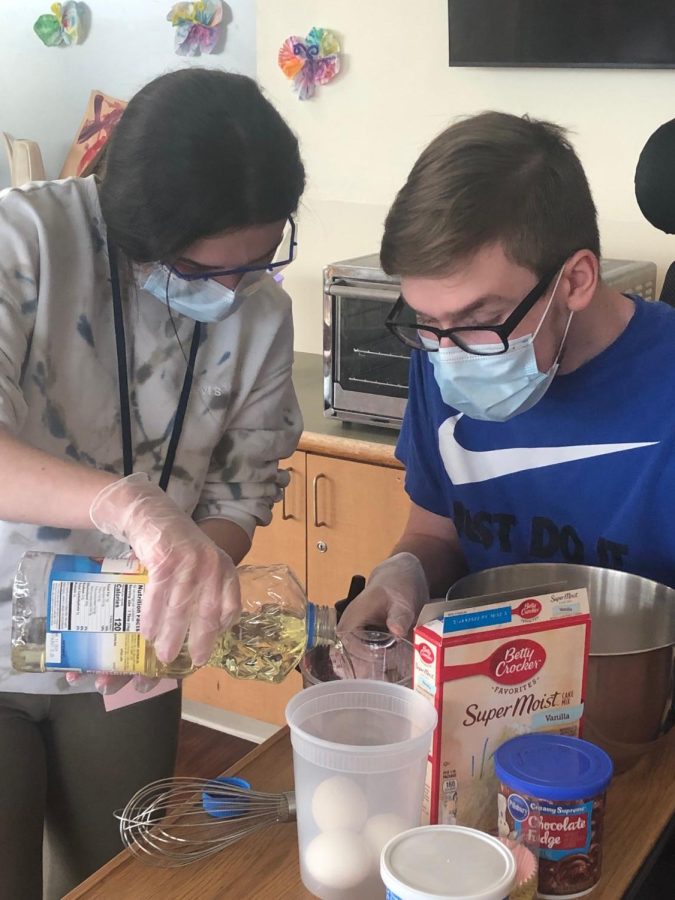 A volunteer bakes with a VPF resident.