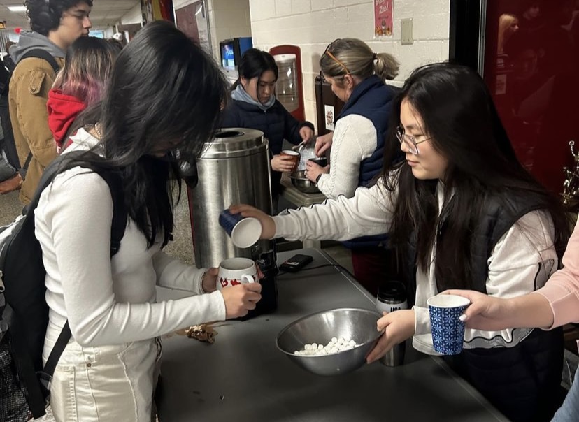 School-wide Vice President Crystal Yeh (24)  gives a student free hot chocolate.