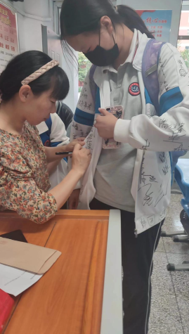 Students from China signing Yuans uniform.