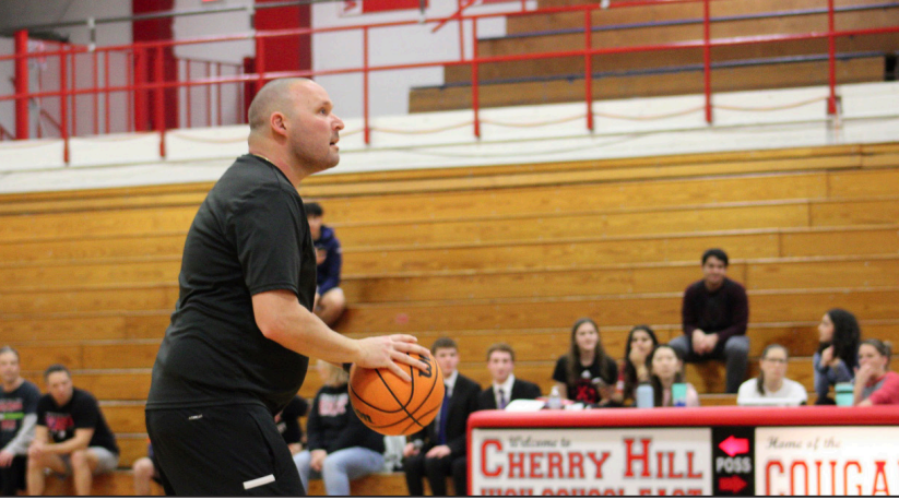 Mr. Michael Mancinelli prepares to shoot a basketball for the staff team.