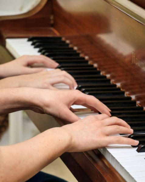 An example of a piano duet, where four hands are used to produce music instead of just two.