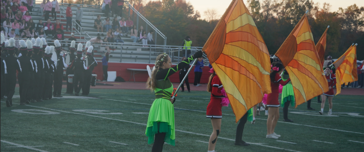 The color guard and marching band perform at the football game against West Deptford High School.