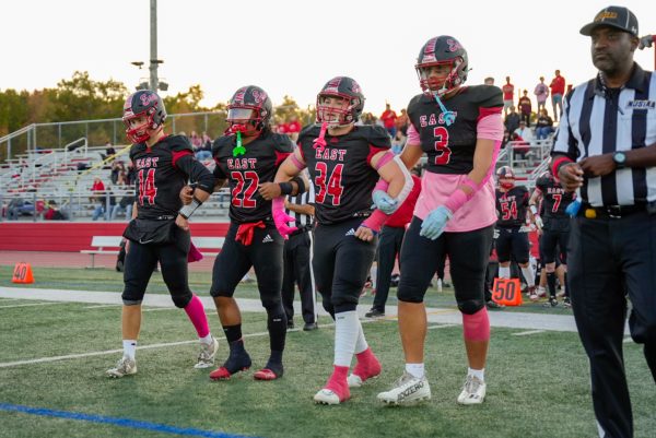 Denzel Lee ('25), Dominic Tomasetti ('25), Zach Salsbery ('25), and Jaxson Bowman ('25) walking down the field together before their final home game.