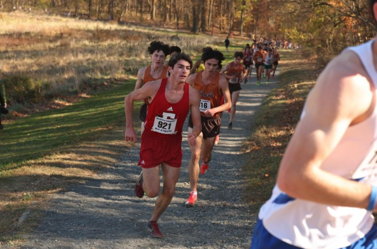 Brody Bogos ('25) runs in a cross country race for East.