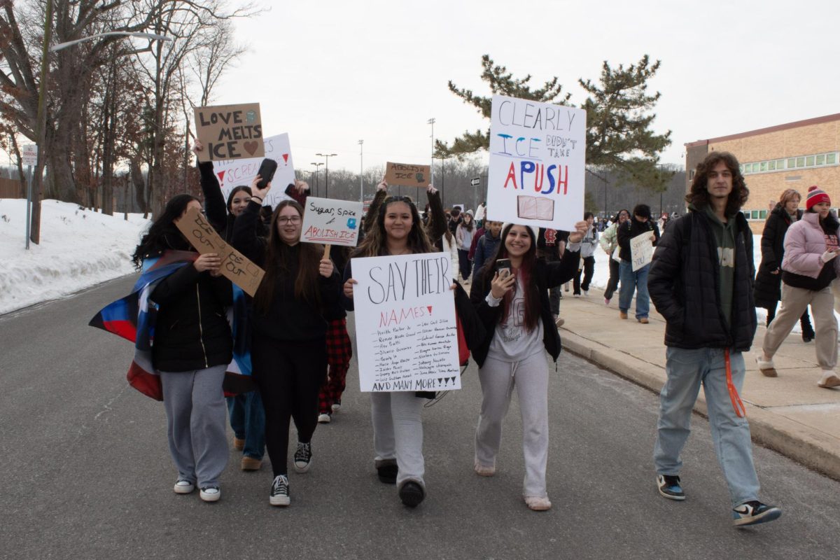 Students walk toward the annex, showing off their posters.