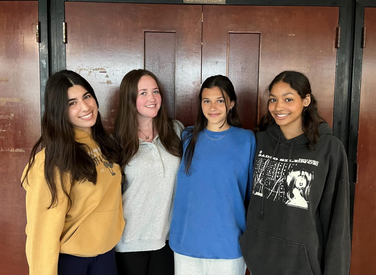 The chairpeople for Mr. East pose in front of the auditorium doors. From left to right: Shia Snyder ('26), Alexis Nowakowski ('26), Claudia Fulginiti ('26) and Akira Gordon ('26). 