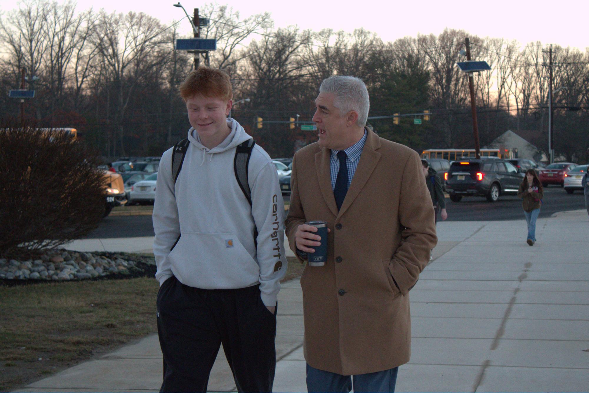 Dr. Neil Burti greets Stephen Longo ('26) outside the student entrance in the morning. 