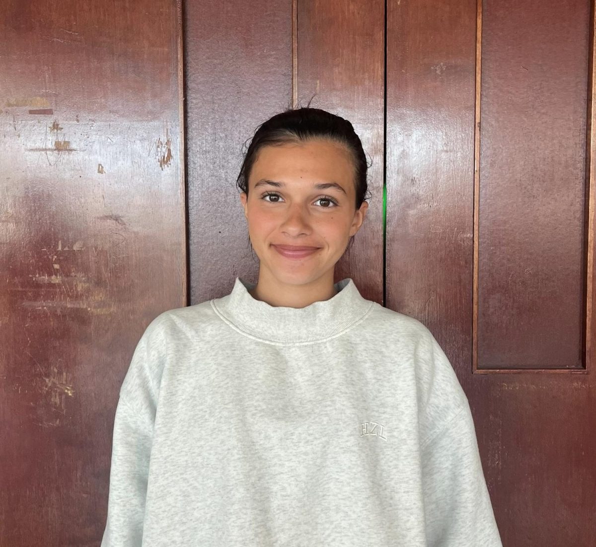 Claudia Fulginiti ('26) poses in front of the auditorium doors. 