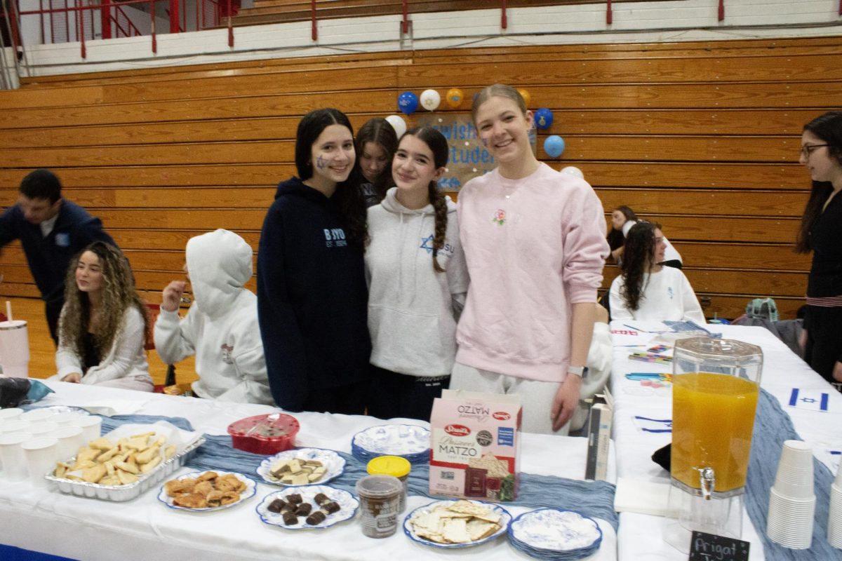 Jewish Student Union members pose for a photo behind their booth.