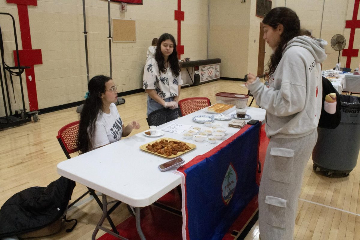 The Pacific Islanders Culture Society speaks with a student at their MCD booth. 