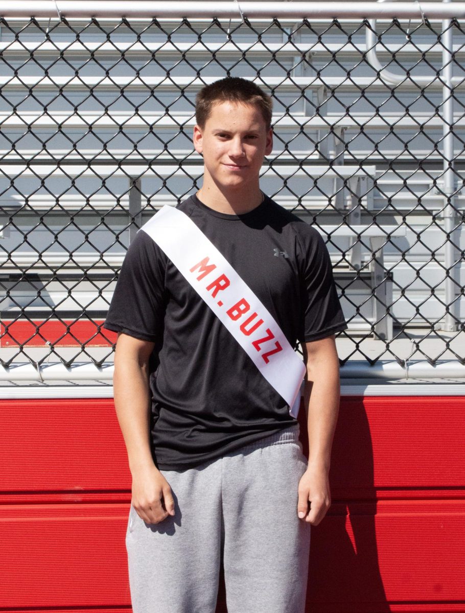 Nolan Perry ('26) poses for a photo with his Mr. East sash, assuming the identity of Mr. Buzz.