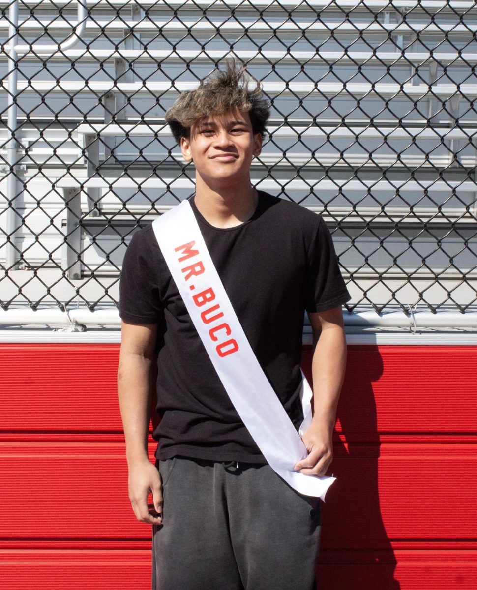Nathan Aguelo ('26) poses for a photo with his Mr. East sash, assuming the identity of Mr. Buco.