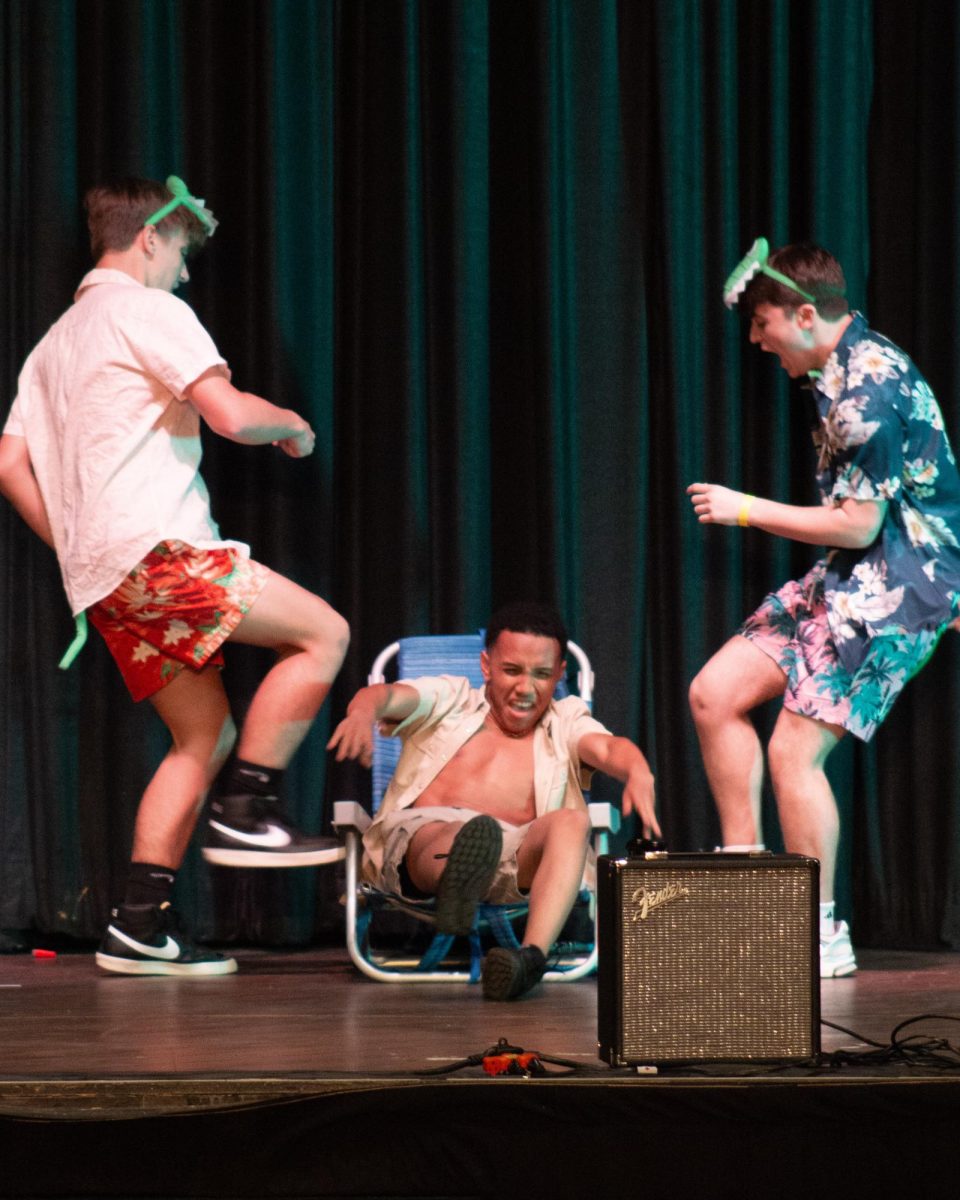 Mr. Renaissance Man pretends to be kicked by members of his act.