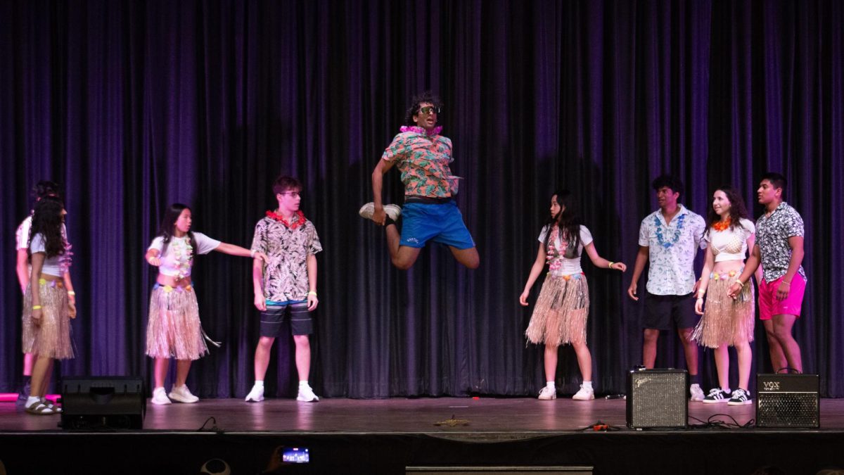 Mr. Samuscular jumps in the air surrounded by members of his act.