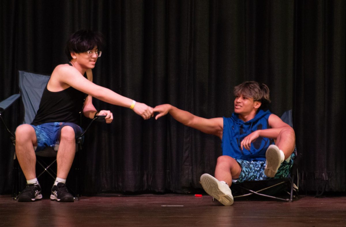Before starting his act, Mr. Buco does a handshake with Nathan Le ('26).