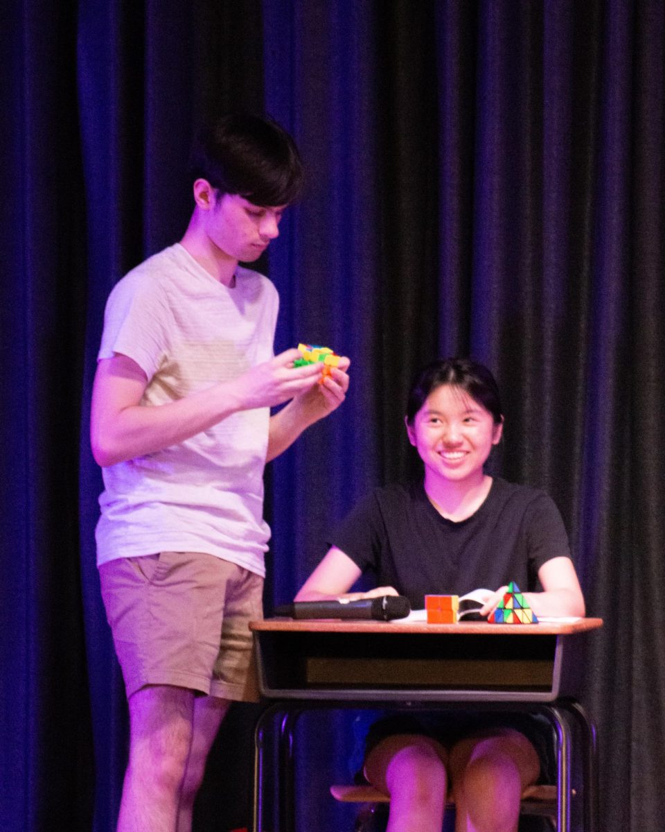Mr. Know-It-All solves three Rubik's Cubes while singing "The Final Countdown."