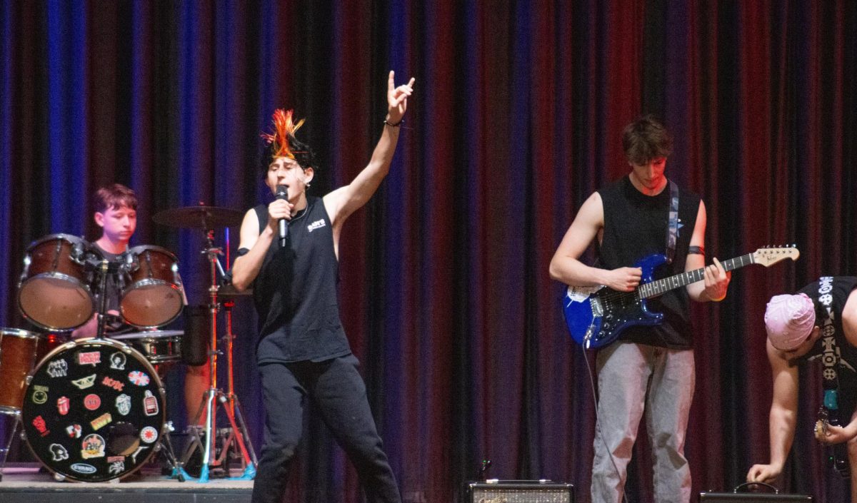 Mr. Slaughter sings "American Idiot" while members of his act play accompanying instruments. 