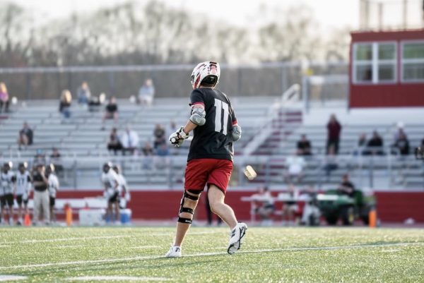 Hunter Sobus ('26) runs across lacrosse field mid-game