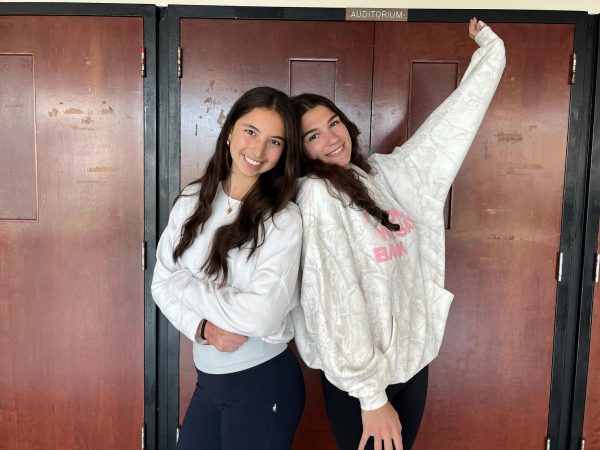 The choreographers for Mr. East pose together at the doors of the auditorium. From left to right: Rachel Rosenberg ('26), Gabby Koren ('26).