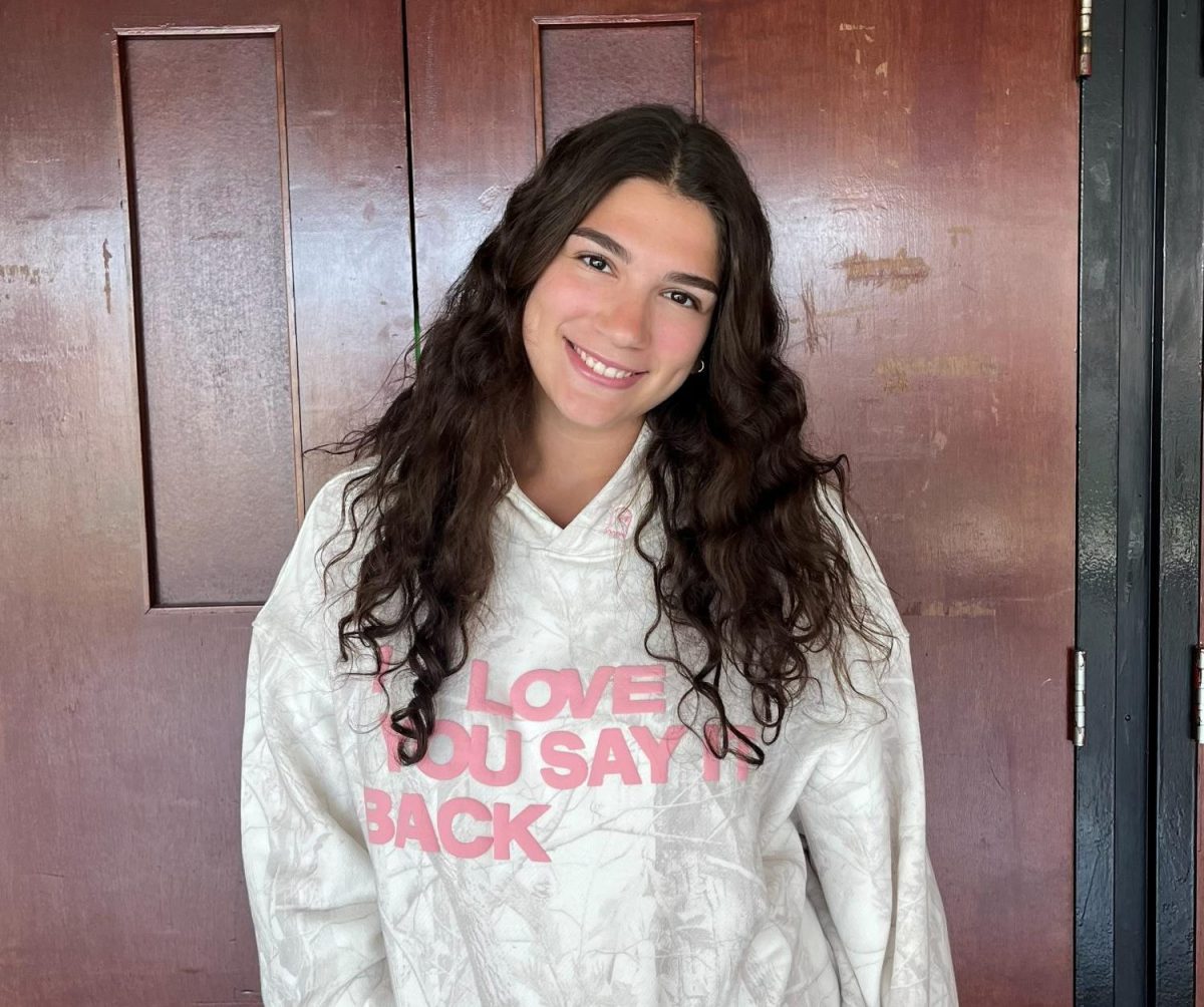 Gabby Koren ('26) poses in front of the auditorium doors. 