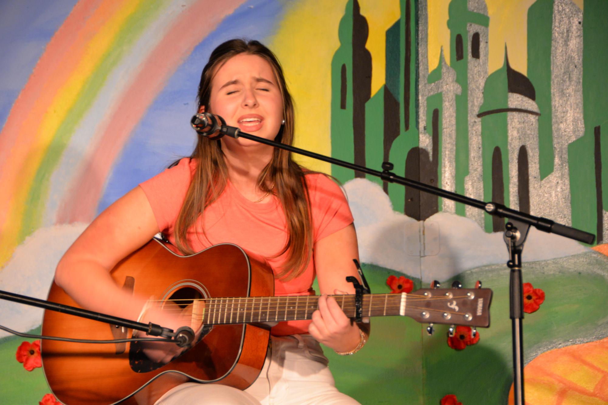 Chairperson Fiona Houston ('27) performs a song at Coffeehouse to honor her brother's story.