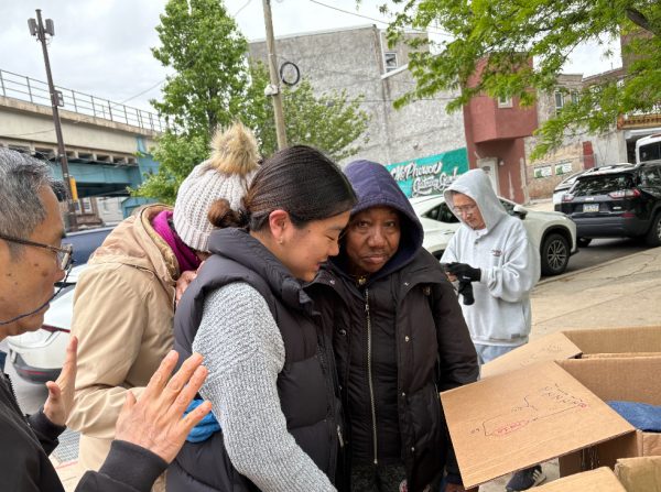 Kang ('28) prays for a woman on the streets of Kensington. Used with permission from Emmanuel Church in Philadelphia. 