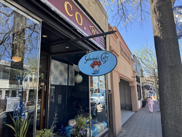 A sign for Sabrina's Cafe in Collingswood hangs above the sidewalk. 